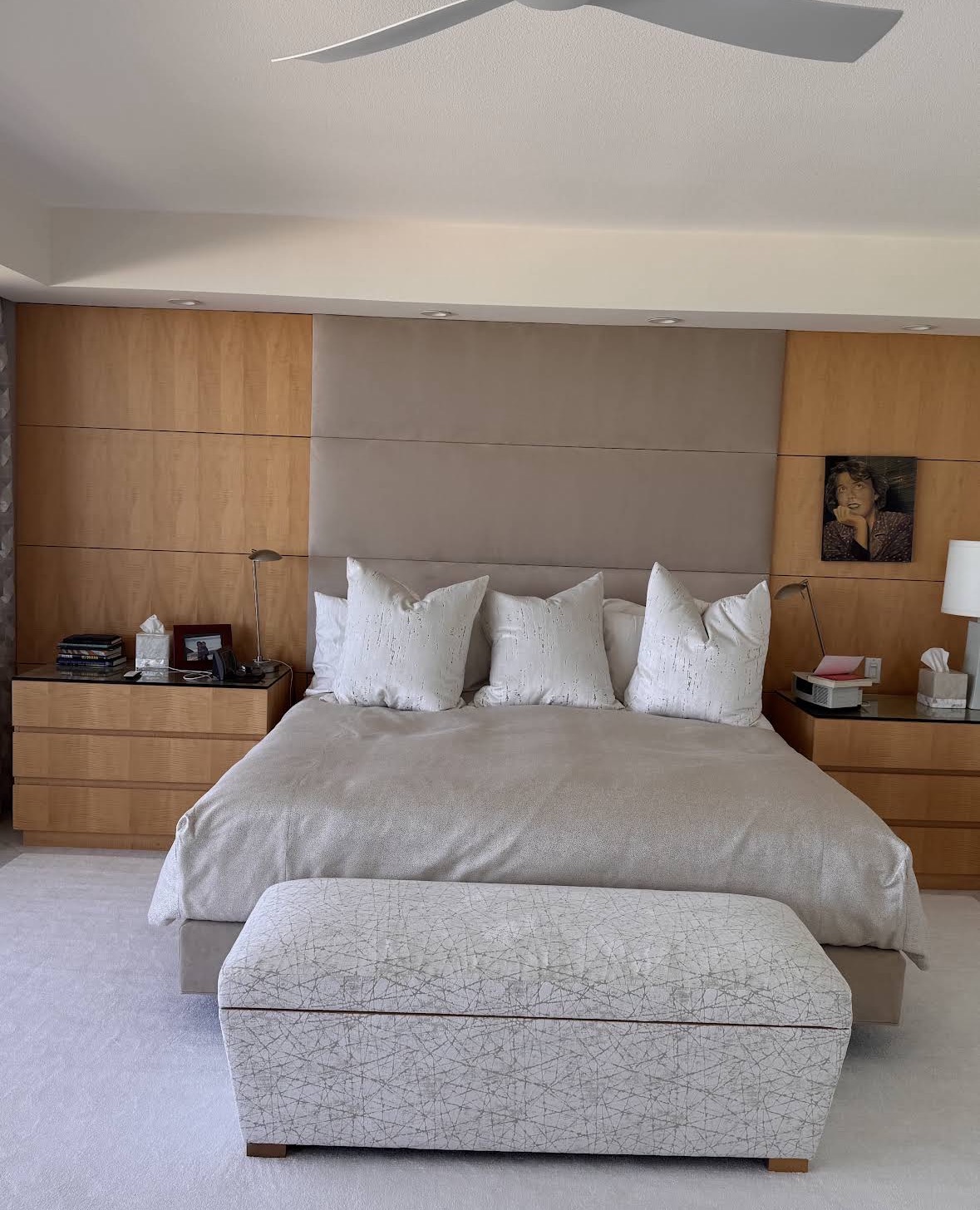 Upholstered headboard wall panels behind a luxury master bed